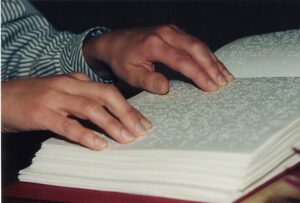 Lesende Hände auf einer Braille-Seite